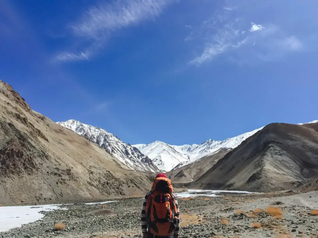 A man doing High Altitude Trekking in Nepal with beautiful view of mountain in the back