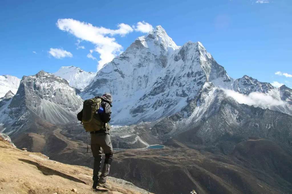 A man hiking in Nepal with light backpack and clear mountain view